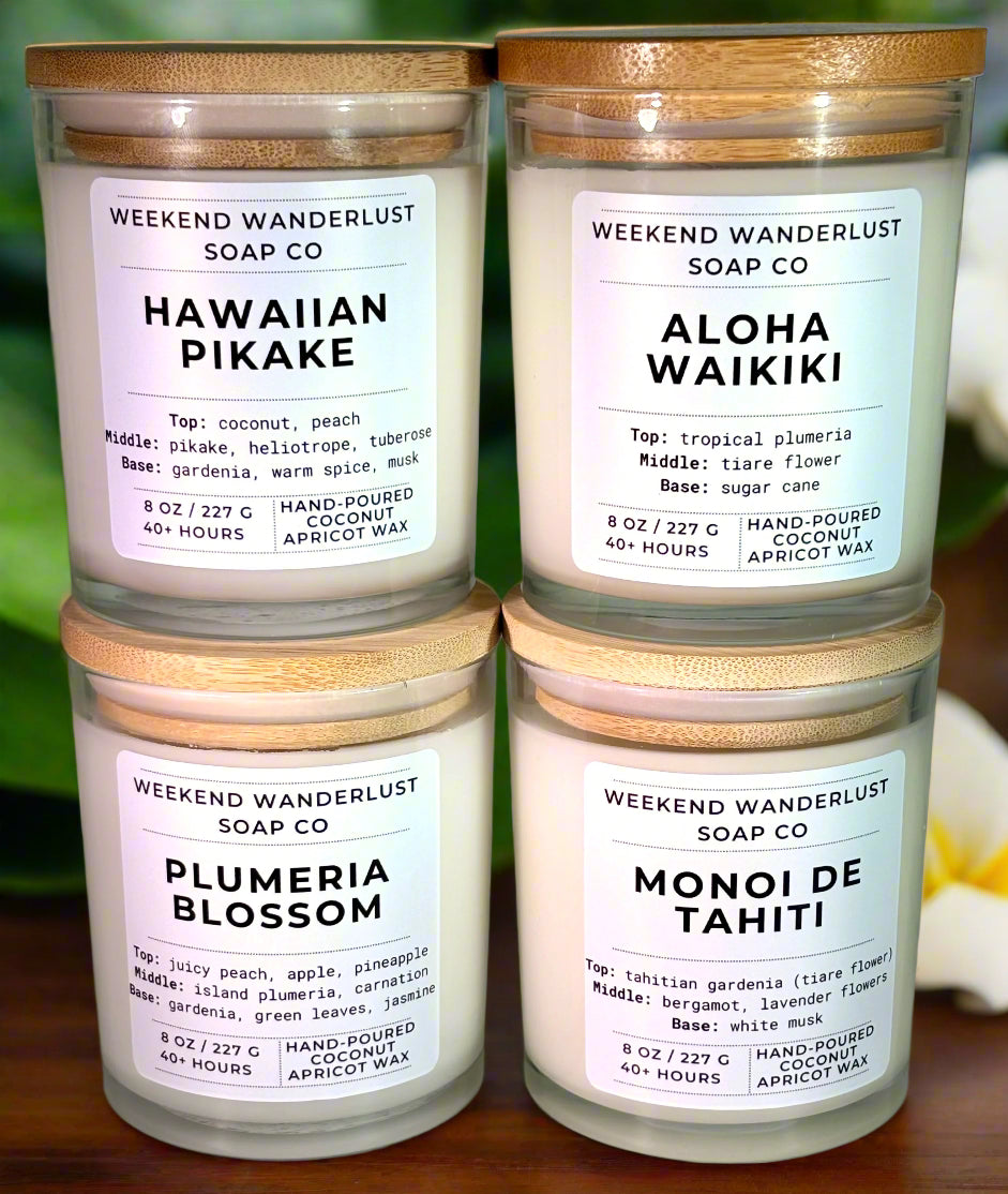 Four candles from Weekend Wanderlust Soap Co with labels on a floral background