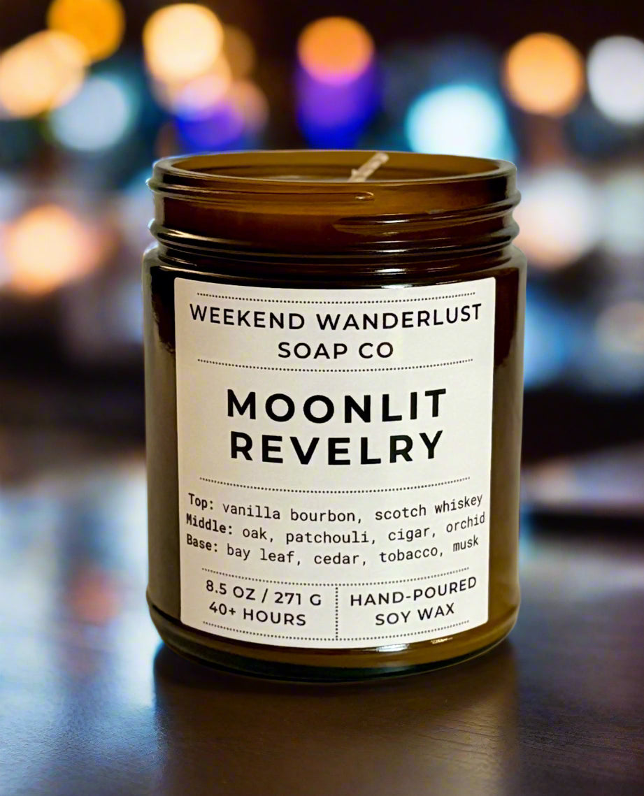 Candle jar labeled 'Moonlit Revelry' from Weekend Wanderlust Soap Co on a blurred background