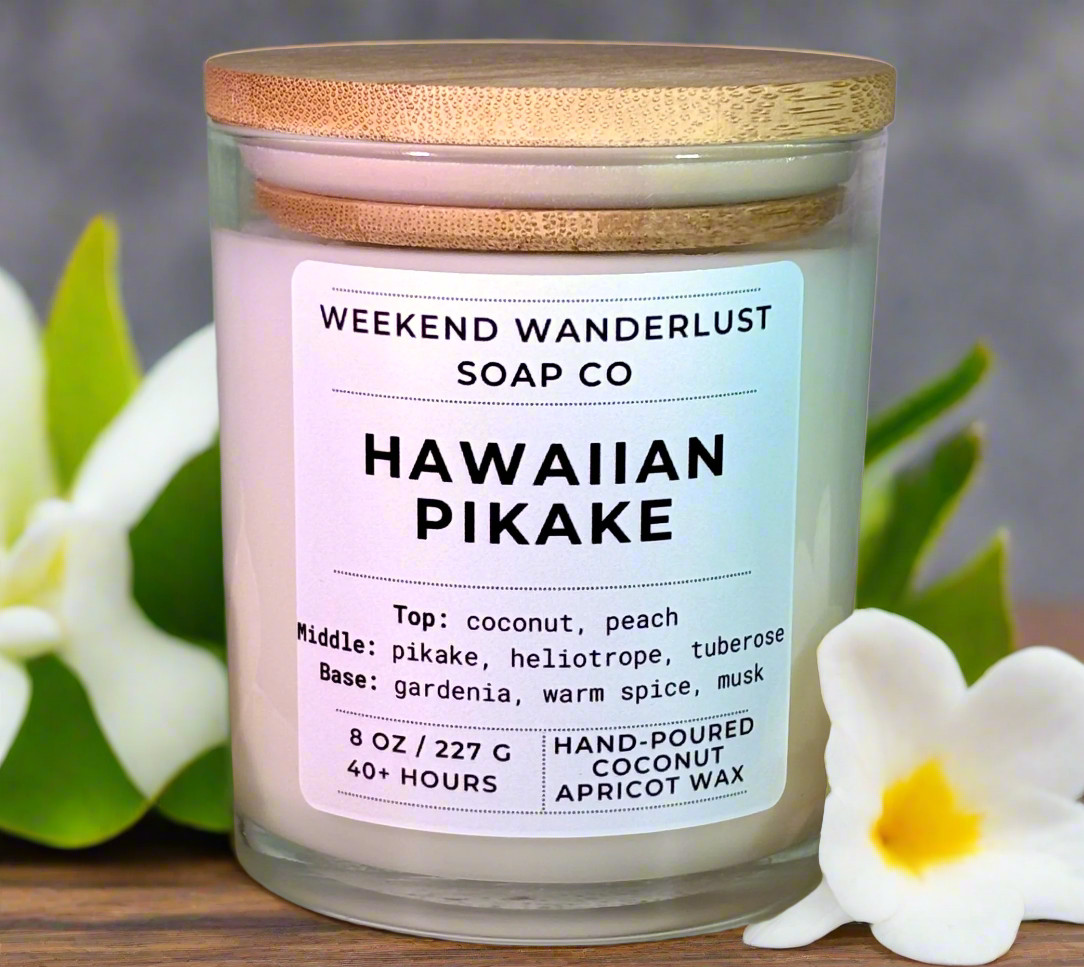 Hawaiian Pikake candle with a label from Weekend Wanderlust Soap Co, surrounded by flowers.