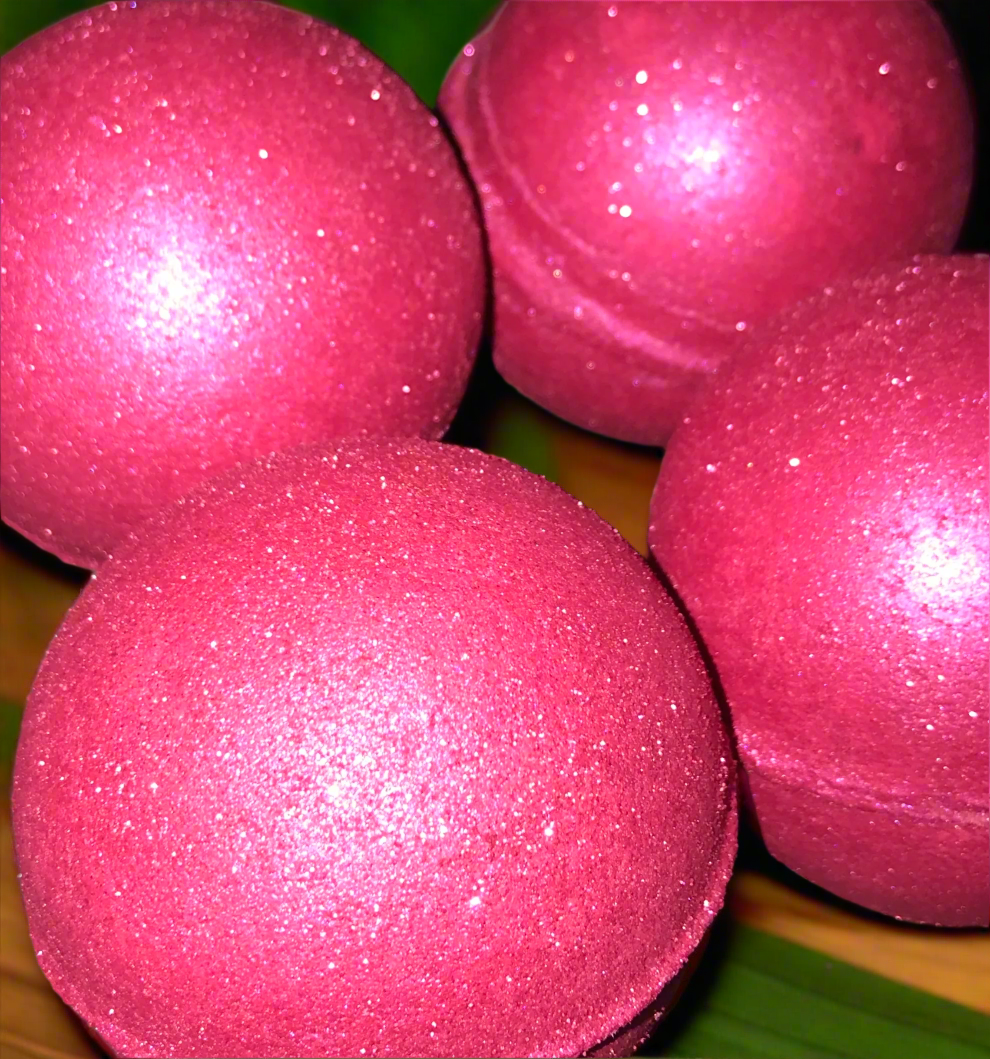 Close-up of pink glittery bath bombs on a green and brown background