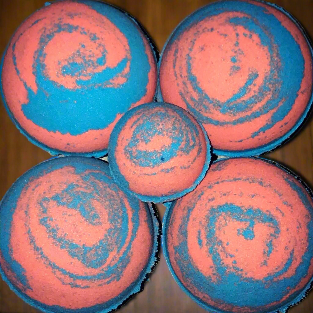 Five pink and blue swirled bath bombs on a wooden surface