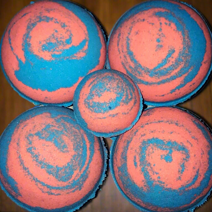Five pink and blue swirled bath bombs on a wooden surface
