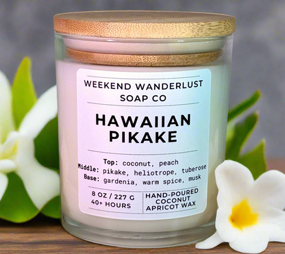 Hawaiian Pikake candle with a label from Weekend Wanderlust Soap Co, surrounded by flowers.