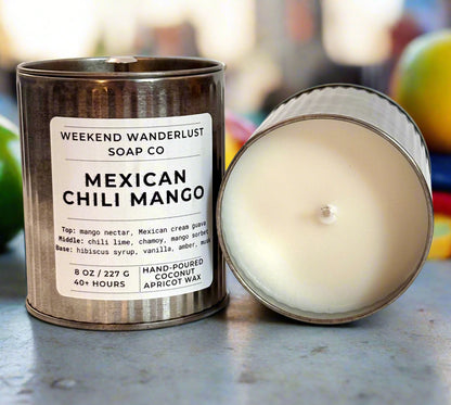 Candle in a metal tin with a label for 'Weekend Wanderlust Soap Co. Mexican Chili Mango' on a white background.