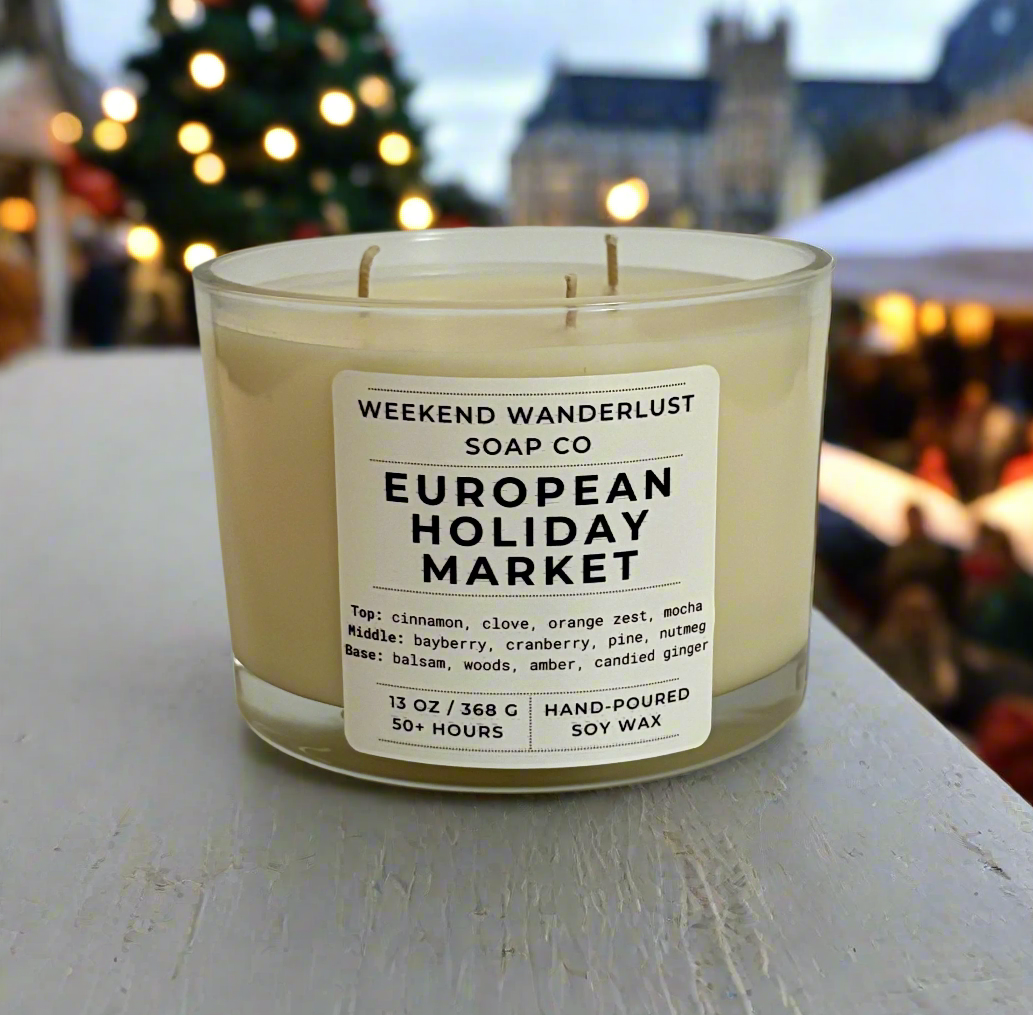 Candle with 'Weekend Wanderlust Soap Co' label in a festive outdoor setting