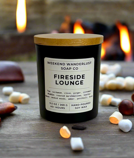 Candle labeled 'Fireside Lounge' from Weekend Wanderlust Soap Co. with a fireplace in the background.