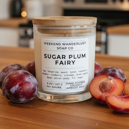 Glass candle with wooden lid labeled 'Sugar Plum Fairy' from Weekend Wanderlust Soap Co on a white background